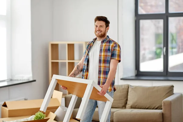 Happy man with table moving to new home — Stock Photo, Image