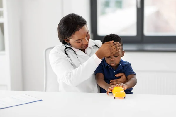 Doctor with measuring babys temperature at clinic — Stock Photo, Image