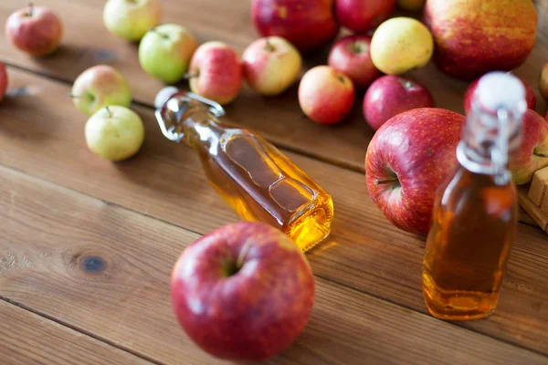 Flaschen Apfelsaft oder Essig auf Holztisch — Stockfoto