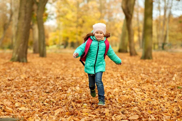 Chica estudiante feliz con mochila en el parque de otoño —  Fotos de Stock