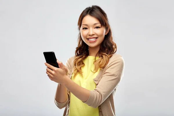 스마트폰을 사용하는 행복 한 동양 여성 — 스톡 사진