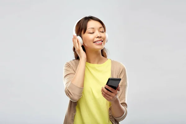Mujer asiática en auriculares escuchando música —  Fotos de Stock
