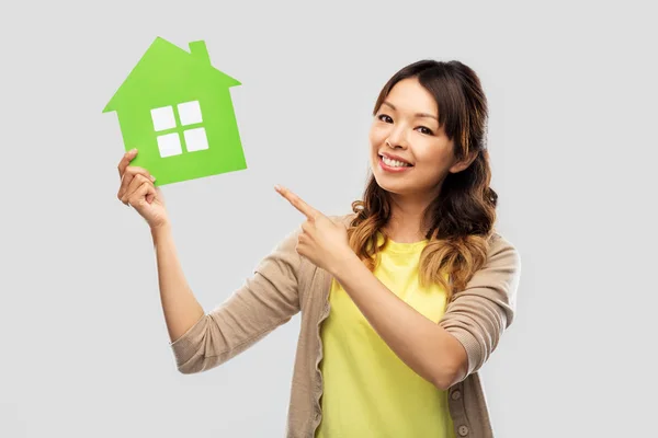 Felice donna asiatica mostrando casa verde — Foto Stock