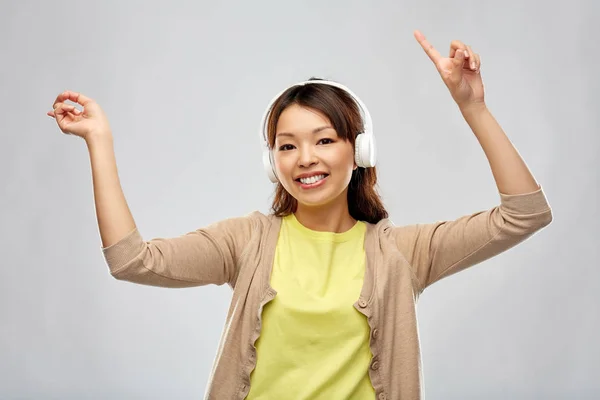 Asiatico donna in cuffie ascolto di musica — Foto Stock