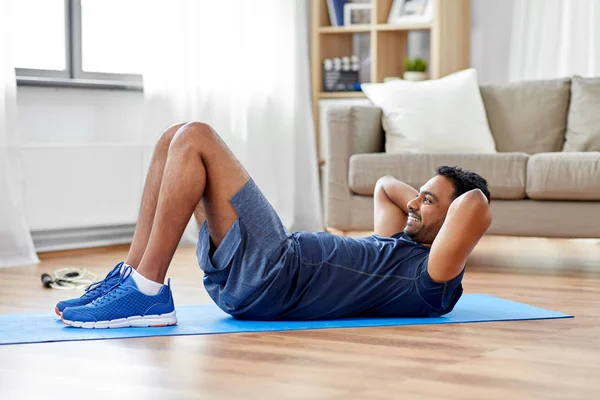 Hombre indio haciendo ejercicios abdominales en casa —  Fotos de Stock