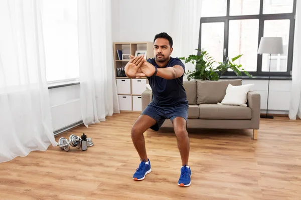 Indian man exercising and doing squats at home — Stock Photo, Image