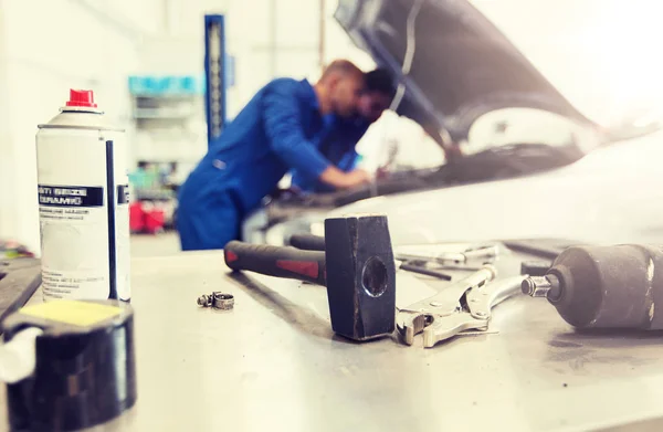 Рабочий инструмент и человек ремонт автомобиля в мастерской — стоковое фото