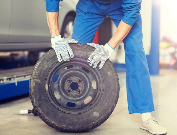 Mekaniker med hjul däck på bilverkstad — Stockfoto