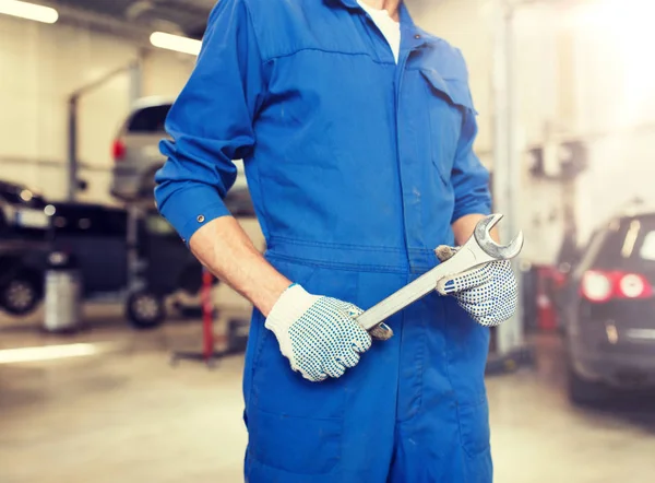 Auto mechanic or smith with wrench at car workshop — Stock Photo, Image