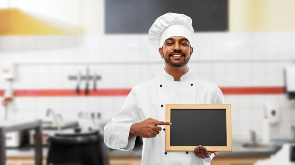 Indischer Koch mit Tafel in der Restaurantküche — Stockfoto