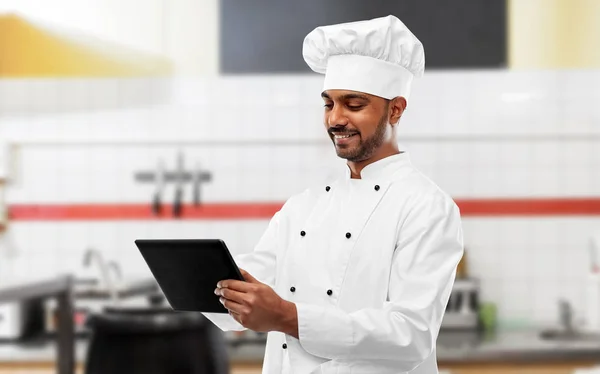 Индийский шеф-повар с планшетным ПК на кухне ресторана — стоковое фото