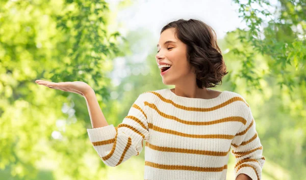 Vrouw met lege hand over natuurlijke achtergrond — Stockfoto