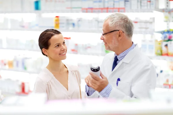 Apothicaire et femme avec des médicaments à la pharmacie — Photo