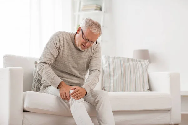 Hombre mayor que sufre de dolor de rodilla en casa — Foto de Stock