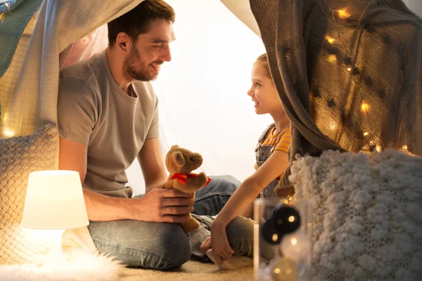 Famiglia felice che gioca con il giocattolo nella tenda dei bambini a casa — Foto Stock