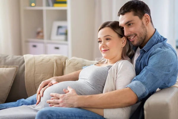 집에서 임신 한 여자를 껴안고 있는 남자 — 스톡 사진