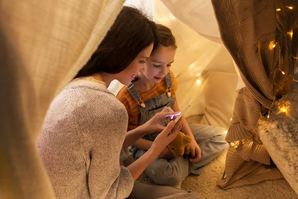 Evde çocuk çadırında akıllı telefonu olan mutlu bir aile. — Stok fotoğraf