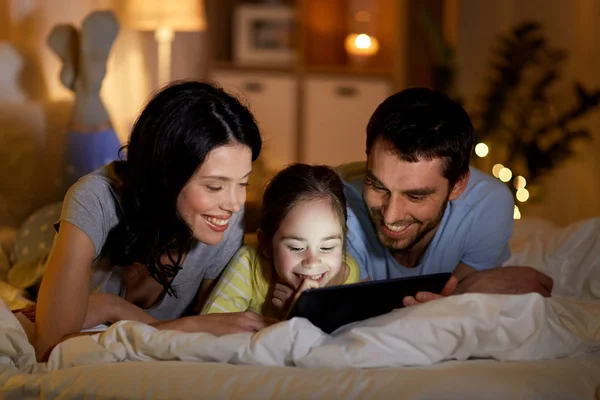 Familie mit Tablet-PC nachts zu Hause im Bett — Stockfoto