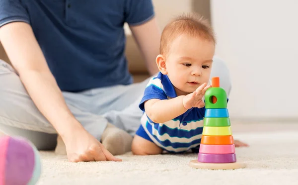 Menino com pai e brinquedo pirâmide em casa — Fotografia de Stock