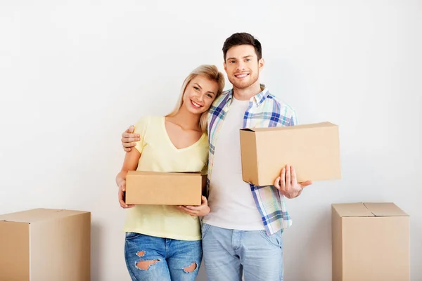 Gelukkig paar met dozen verhuizen naar nieuw huis Stockafbeelding