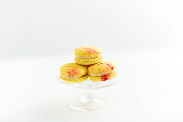 Lemon yellow macarons on glass confectionery stand — Stock Photo, Image