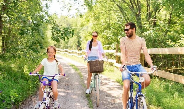 Happy family with bicycles in summer park — Stock Photo, Image