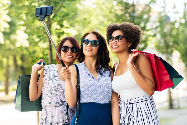 Ženy s nákupními taškami s selfie venku — Stock fotografie