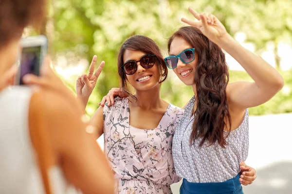 Vrouw fotograferen haar vrienden in de zomer park — Stockfoto