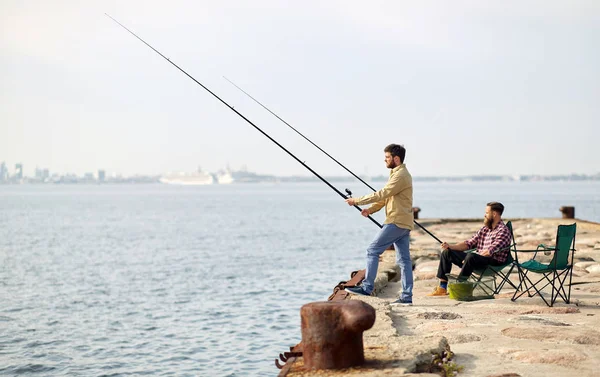 Amici felici con canne da pesca sul molo — Foto Stock