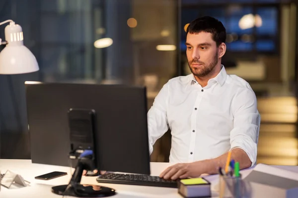 Homme d'affaires avec ordinateur travaillant au bureau de nuit — Photo