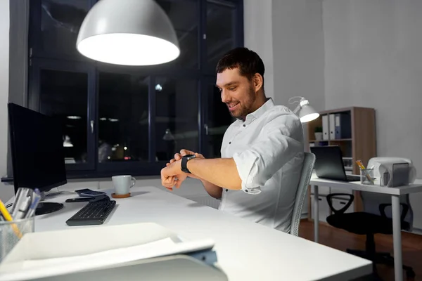 Homme d'affaires heureux en utilisant la montre intelligente au bureau proche — Photo