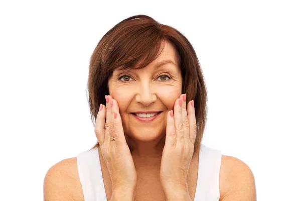 Retrato de mujer mayor sonriente tocándose la cara — Foto de Stock