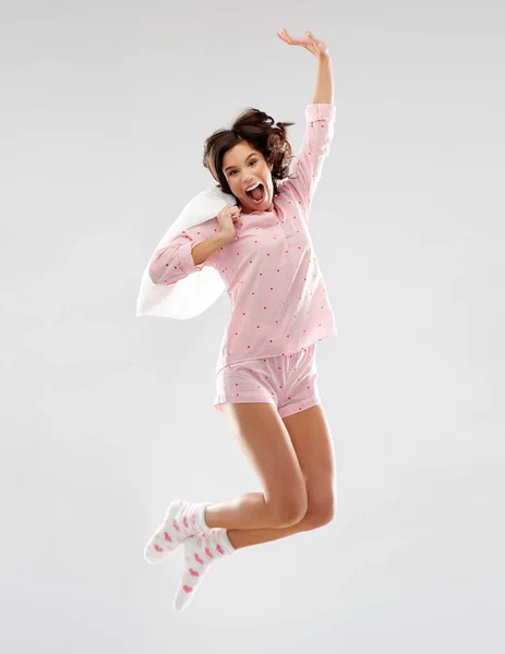 Mujer feliz en pijama saltando con almohada — Foto de Stock