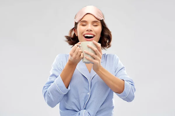 Vrouw in pyjama en slapende masker drinken koffie — Stockfoto