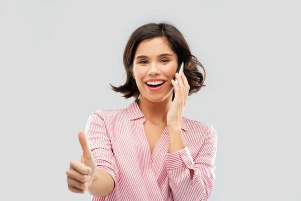 Mulher chamando no smartphone e mostrando os polegares para cima — Fotografia de Stock