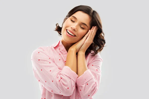 Mujer feliz en pijama haciendo el gesto de dormir —  Fotos de Stock