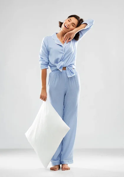 Gelukkig slaperig vrouw in blauw pyjama holding kussen — Stockfoto