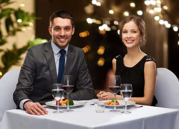 Couple with food and red wine at restaurant — Stock Photo, Image