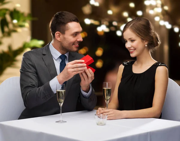 Mann zeigt Frau in roter Schachtel in Restaurant — Stockfoto