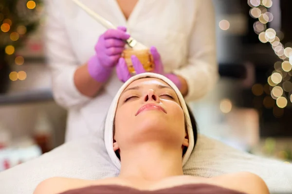 Esteticista aplicando mascarilla facial a mujer en spa —  Fotos de Stock