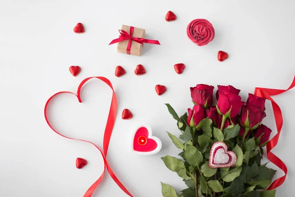 Close up de rosas vermelhas, presente, doces e vela — Fotografia de Stock