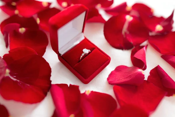 Diamond ring in red velvet gift box on bed sheet — Stock Photo, Image