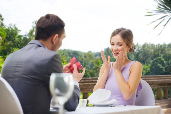 Чоловік показує жінку, присутню в червоній коробці в ресторані — стокове фото