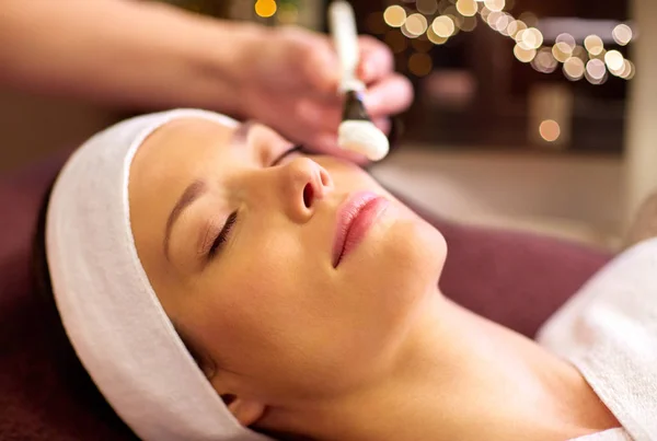 Esteticista aplicando mascarilla facial a mujer en spa — Foto de Stock