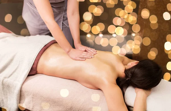 Woman lying and having back massage at spa parlor — Stock Photo, Image