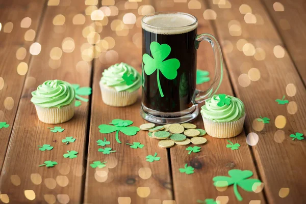 Shamrock op glas bier, groene cupcake en munten — Stockfoto
