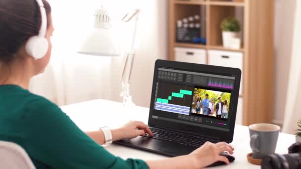 Mujer con programa de editor de vídeo en el ordenador portátil en casa — Vídeos de Stock