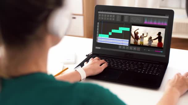 Mulher com programa editor de vídeo no laptop em casa — Vídeo de Stock