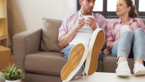 Pies de pareja bebiendo café en casa nueva — Vídeos de Stock