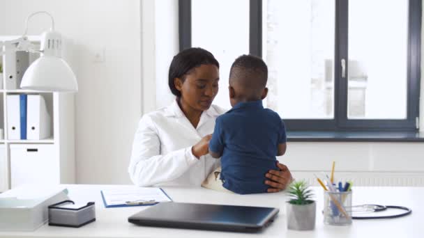 Lekarz lub pediatra z dzieckiem w klinice — Wideo stockowe